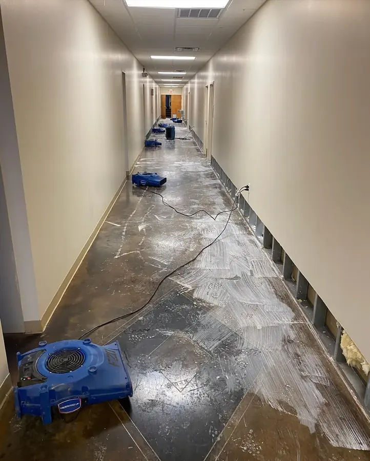 Air mover drying a tiled corridor after water damage